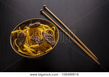 Food Knitted From Woolen Thread Lies On A Plate, As A Japanese Dish Of Meat And Noodles, Lie Next To