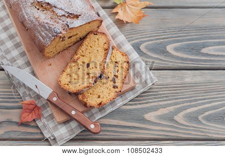 Homemade cake with dried apricots and raisins on wooden background.  Autumn still life.