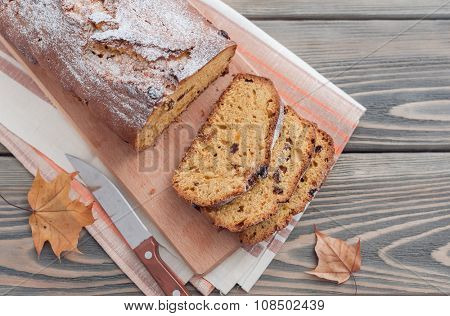 Homemade cake with dried apricots and raisins on wooden background.  Autumn still life.