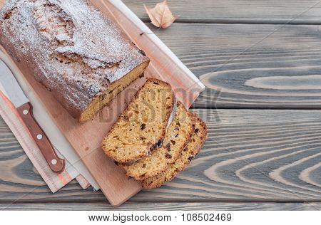 Homemade cake with dried apricots and raisins on wooden background.  Autumn still life.