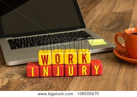 Work Injury written on a wooden cube in a office desk