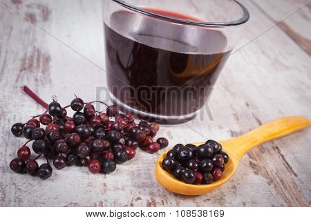 Fresh Elderberry With Wooden Spoon And Juice On Old Wooden Background, Healthy Nutrition