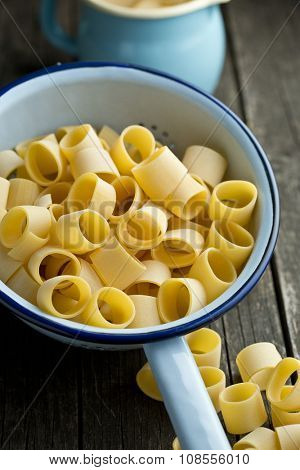 uncooked pasta calamarata in colander