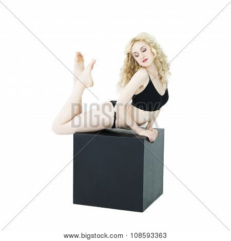 Slim Young Woman Makes Yoga Asana On Black Cube