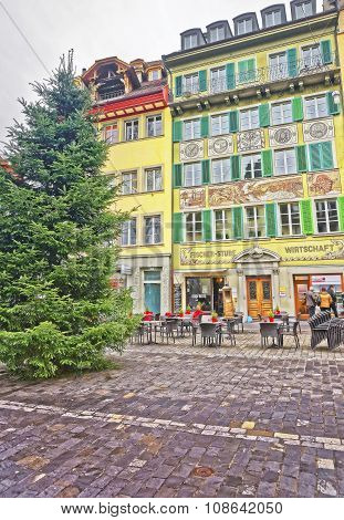 LUCERNE SWITZERLAND - JANUARY 06 2015: Christmas tree near a traditional street cafe on the right bank of the River Reuss at a picturesque square Muhlenplatz in Lucerne Switzerland.