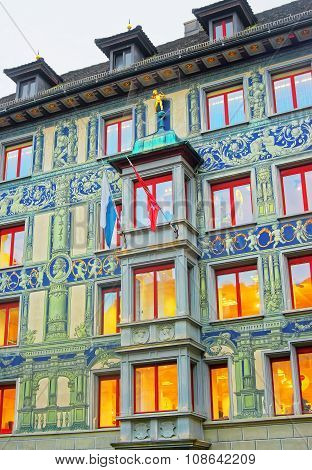 Exterior of the building with frescos and a figure of a golden bow boy in the old town center of Lucerne in Switzerland.
