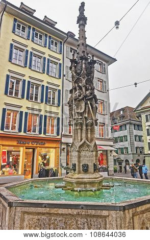 LUCERNE SWITZERLAND - JANUARY 04 2015: Buildings decorated with frescos and Weinmarkt fountain in Old Town of Lucerne Switzerland. Gothic Fountain depicts St. Mauritius (patron of warriors)