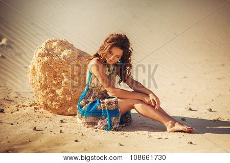 Beautiful young woman in fashion clothes on sand quarry