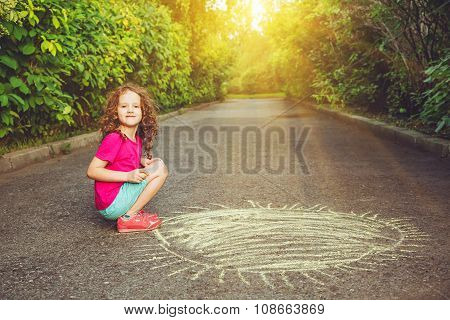 A Child Paints The Sun On The Asphalt.