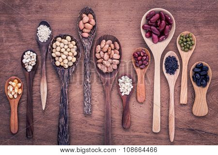 Assortment Of Beans And Lentils In Wooden Spoon On Teak Wood Background. Mung Bean, Groundnut, Soybe