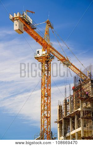 Yellow crane in Construction Site on blue sky.