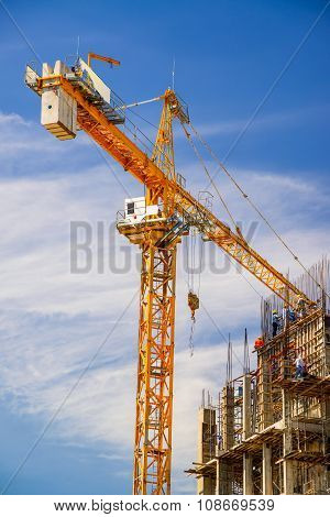 Yellow crane in Construction Site on blue sky.