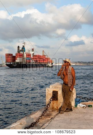 HAVANA, CUBA - MAY 19: Unknown Cuban fisherman catches a fish at the Malecon seawall on May 19, 2013 in Havana, Cuba. Fishing in the city helps to replenish the meager diet of poor people in Havana