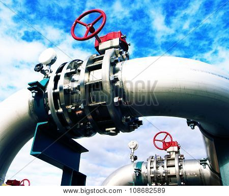 Industrial Zone, Steel Pipelines And Valves Against Blue Sky
