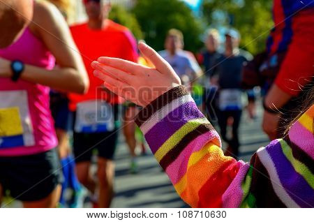 Marathon running race, support runners on road, child's hand giving highfive, sport concept