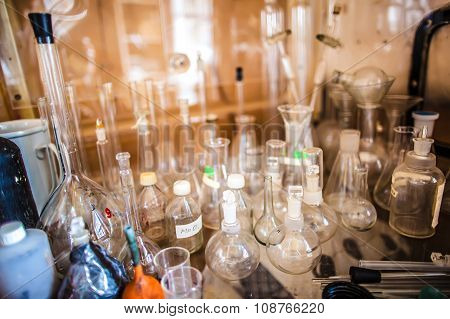 Glass Bottles, Test Tubes, Flasks And Cups In An Old Chemical Laboratory
