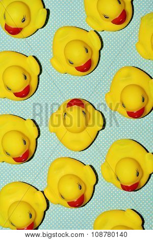 a pile of rubber ducks, one of them countercurrent, on a dot-patterned background, with a hard-shadow processing