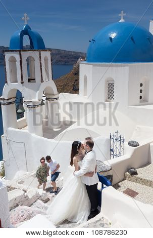 A Couple Of Newlywed’s Tourists In Front Of Church With The View Of Santorini Island, In Greece. Tou