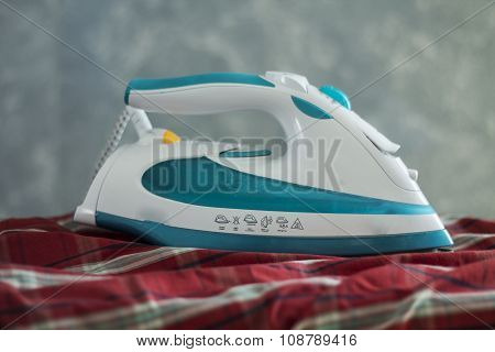 Steam Iron On A Red Checked Fabric