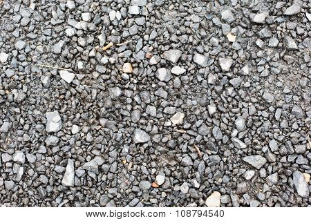 background and texture concept - close up of gray macadam stones on ground