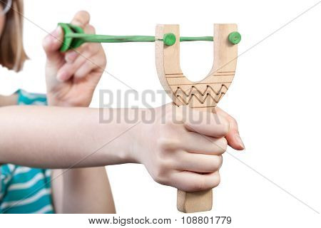 Girl Pulls Green Rubber Band Of Wooden Slingshot