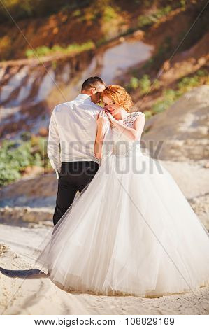 Bride and groom on their wedding day in sand quarry