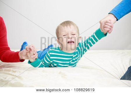 divorced parents holding sad child separately