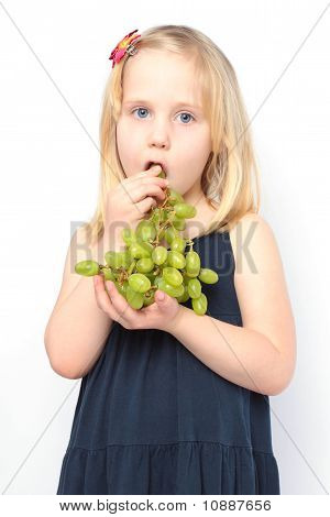 Bambino bella ragazza mangia uva verde
