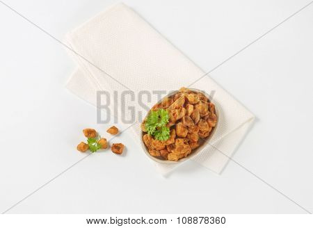 plate of salty pork greaves on white napkin