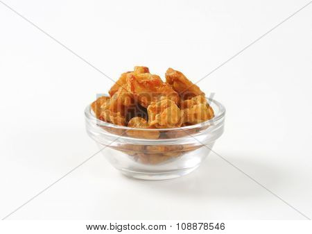 bowl of salty pork greaves on white background