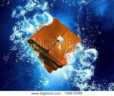 Unemployment concept with biefcase sink in clear blue water
