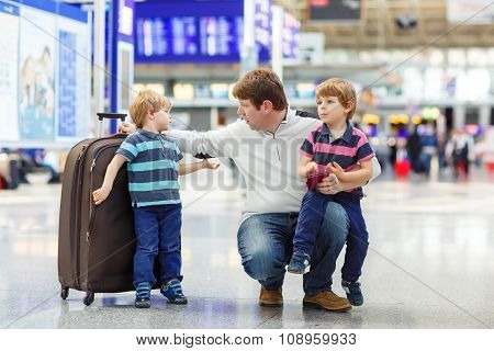 Father and two little sibling boys at the airport