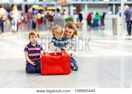 Mother and two little sibling boys at the airport