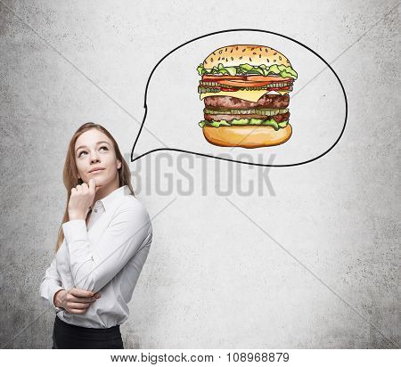A Beautiful Woman Is Thinking About Burger. A Fast Food Concept. Concrete Background.