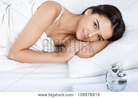 Pleasant girl lying in bed