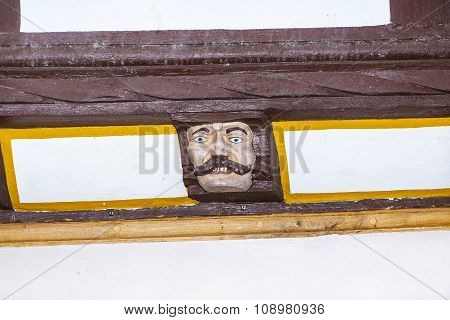 Wood Carving With Funny Faces On Timber Balk  Of Old Framework Houses