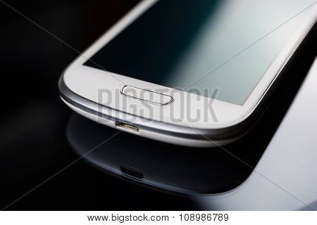 A White Smartphone On A Tablet