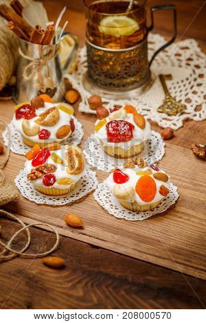 Traditional Easter cake with decorations and cupcakes on wooden table