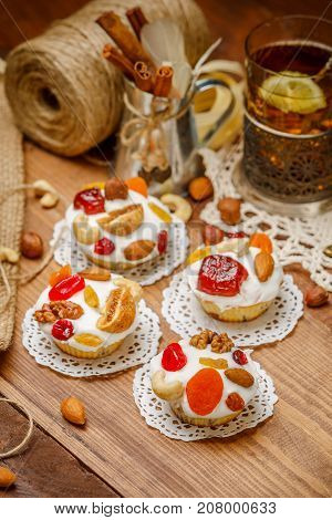Traditional Easter cake with decorations and cupcakes on wooden table