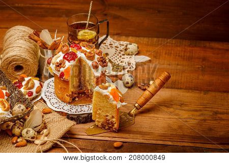 Traditional Easter cake with decorations and cupcakes on wooden table