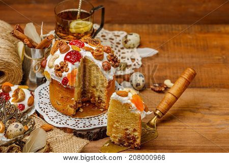 Traditional Easter cake with decorations and cupcakes on wooden table