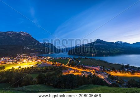 Night panorama of Lake Lucerne. Mountain range snow on the tops of the mountains. Axenstrasse. Lights in the houses and along the road. Switzerland Alps.