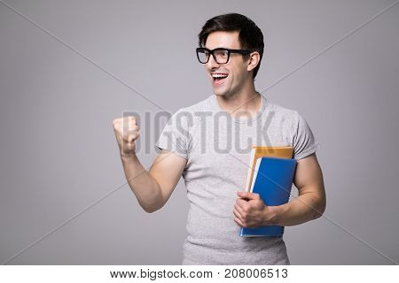 Happy Student Holding Notebook, Guy Wearing Gray T-shirt And Jeans, Isolated On White Background
