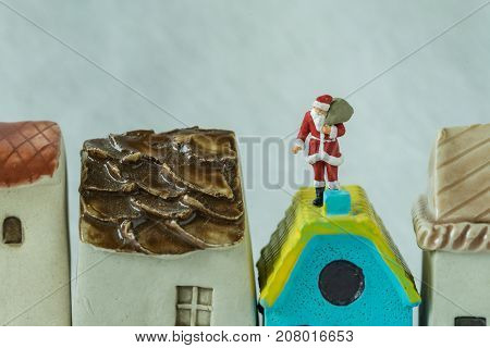 Macro view of miniature figure Santa claus standing on roof chimny as christmas celebration concept.