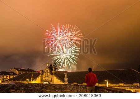 Guy watching fireworks in the local festival of San Froilan in Lugo. Spain.