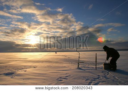 Fisherman On The River Covered With Ice