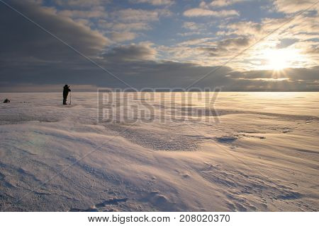 Fisherman On The River Covered With Ice