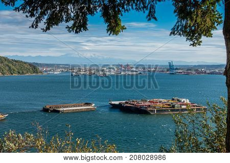 Barges are anchored at the Port of Tacoma with Mount Rainier in the distance.