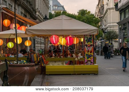 Outdoor street restaurant with people in Budapest.
Budapest Hungary - September 25 2017: Street view of people in outdoor restaurant with colored rice lamps eating dinner. Pedestrian street Vaci utca in Budapest Hungary with incidental people walking by.
