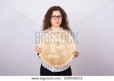 Business woman holding a Golden Bitcoin. Virtual money
